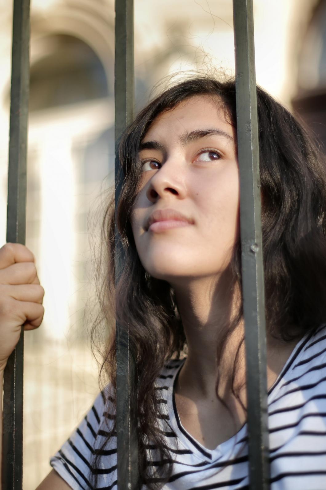 Vrouw kijkt door tralies