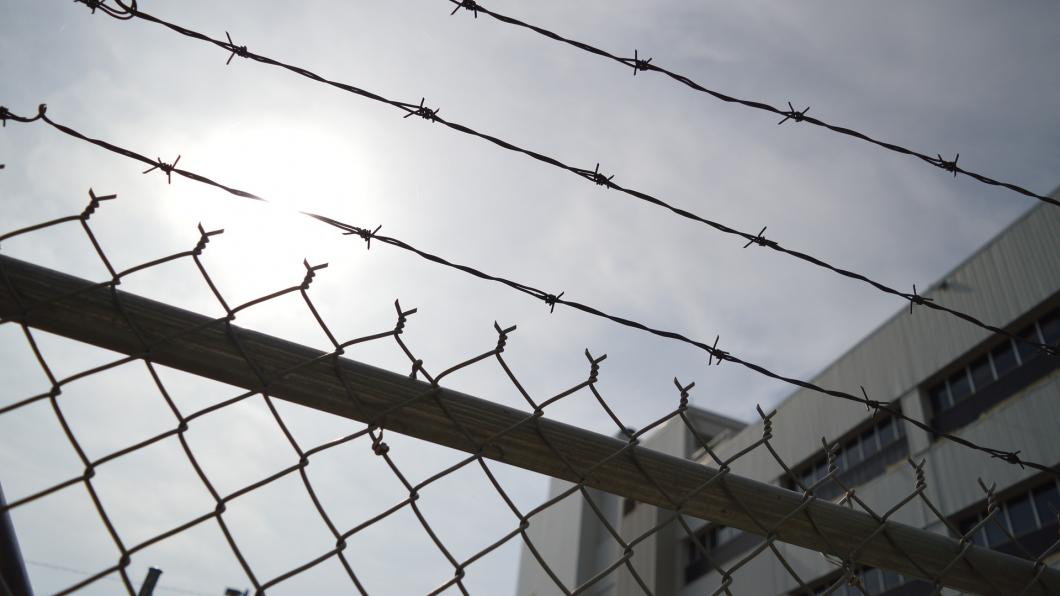 Prikkeldraad boven een hek in de gevangenis